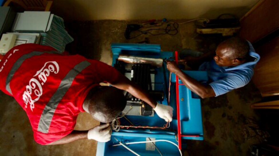 Coca-Cola Technician works on a refrigerator