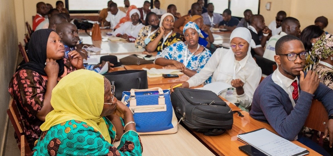 pharmacy students sit at long tables for training in Guinea